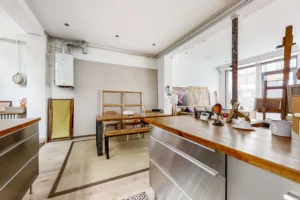 Plan de travail, coin repas et détails industriels dans un loft à l'ambiance authentique.