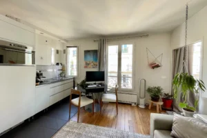 À vendre appartement Paris 18 Abbesses Quality Street Immobilier – séjour lumineux avec coin cuisine moderne et espace bureau.