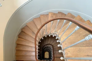 Escalier en bois avec rampe en bois et balustrade en fer forgé, vue plongeante typiquement parisienne.