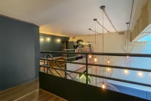 Vue générale de la mezzanine du local commercial restaurant à Paris 10 avec suspensions lumineuses et garde-corps design