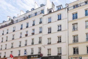 Façades haussmanniennes sur rue animée, commerces à proximité, vie de quartier Paris 11