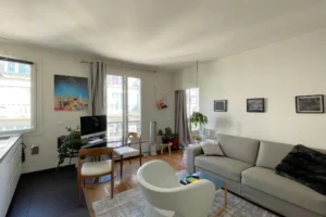 Séjour cosy avec canapé, coin repas et vue dégagée, idéal pour un appartement à Paris 18.