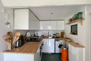 Cuisine équipée et fonctionnelle avec électroménager intégré dans un appartement à vendre à Paris 19, quartier Belleville.