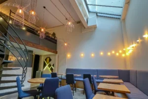 Salle lumineuse du local commercial restaurant à Paris 10 avec verrière, mezzanine et suspension design