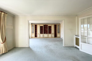 Séjour lumineux avec grande bibliothèque sur mesure dans un appartement à vendre à Paris 16.