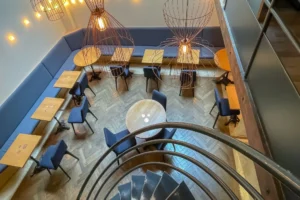Vue depuis la mezzanine du local commercial restaurant à Paris 10 avec banquettes, tables et luminaires suspendus