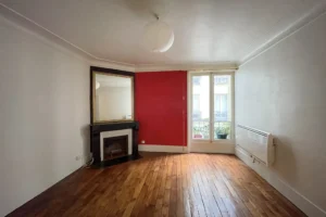 Séjour principal de l’appartement à vendre à Paris par QualityStreet Immobilier, avec cheminée, parquet et miroir.
