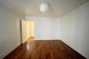 Pièce à vivre avec parquet bois clair et grande hauteur sous plafond.