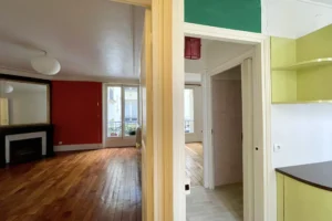 Entrée de l’appartement avec parquet ancien et accès au séjour.