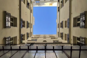 Cour intérieure d’un immeuble haussmannien à Paris, vue verticale sur les étages.