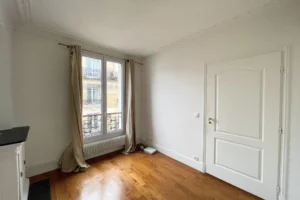 Pièce à aménager avec parquet en bois massif et vue sur les immeubles parisiens typiques du quartier Montmartre, Paris 18ᵉ.