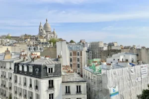 Vue imprenable sur les toits de Montmartre avec le Sacré-Cœur en arrière-plan, depuis un appartement à vendre à Paris 18.