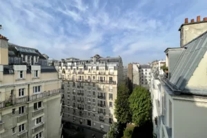 Façades d’immeubles parisiens en brique avec une cour arborée en contrebas, dans le quartier Montmartre, Paris 18e.