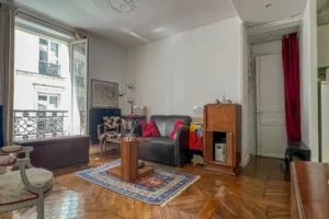Salon avec parquet ancien et belle luminosité dans un appartement à vendre Paris 10, secteur Faubourg Saint-Denis.