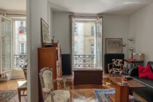 Salon lumineux avec ouvrants en bois, parquet ancien et balcon en fer forgé – Paris 10, secteur Faubourg Saint-Denis.