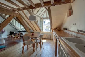 Cuisine ouverte avec vue dégagée sur les toits, pièce à vivre conviviale.