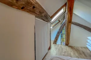 Détail architectural de la mezzanine avec fenêtre de toit et bibliothèque intégrée.