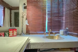 Salle de bain avec plan vasque sur mesure et robinetterie dorée, style vintage.