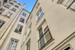 Façade intérieure de l’immeuble parisien, vue depuis la cour, calme et lumineux.