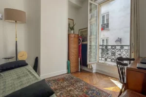 Chambre donnant sur cour avec parquet point de Hongrie et lumière naturelle, dans un appartement à vendre à Paris 10ᵉ, quartier Faubourg Saint-Denis / Paradis.