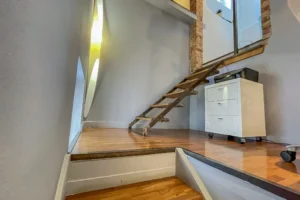Accès mezzanine via escalier bois et métal dans un appartement atypique à vendre dans le 10ᵉ arrondissement.