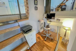 Coin bureau aménagé sous mezzanine avec lumière naturelle, idéal télétravail, dans un appartement à Paris.