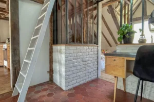Escalier intérieur et verrière atelier donnant sur un coin bureau sous pente.