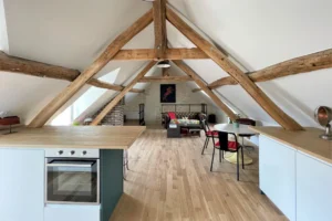 Vue d’ensemble de la pièce à vivre type loft, avec cuisine, coin repas et salon à Chantilly.