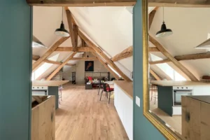 Cuisine ouverte avec ilot central en bois, rangements modernes et lumière traversante à Chantilly.
