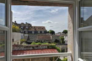 Vue dégagée sur les toits du centre-ville de Chantilly depuis une fenêtre d’appartement.