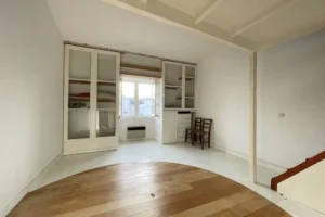 Chambre avec rangements intégrés, penderie vitrée et belle luminosité naturelle.