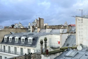 Vue dégagée sur les toits de Paris avec le Sacré-Cœur à l’horizon.