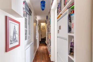 Couloir avec bibliothèque intégrée et parquet ancien dans un appartement à vendre Paris 18 Montmartre