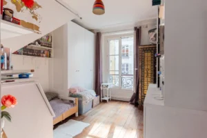 Chambre d’enfant lumineuse avec parquet ancien et grande fenêtre dans un appartement à vendre Paris 18 Montmartre