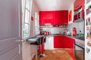 Cuisine équipée moderne avec rangements et coin repas dans un appartement à vendre Paris 18 Montmartre