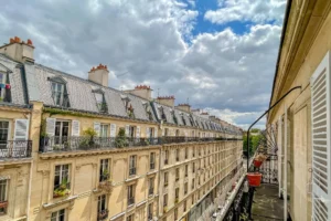 Vue dégagée depuis le balcon sur les toits parisiens et les immeubles en pierre de taille du 11e arrondissement.
