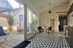 Cuisine noire avec îlot et mur en pierre dans maison à Chantilly