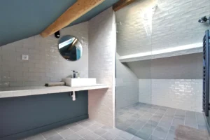 Douche sous combles avec carrelage gris et lumière naturelle à Chantilly