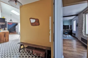 entrée avec un mur jaune qui donne sur une cuisine équipée et aménagée contemporaine