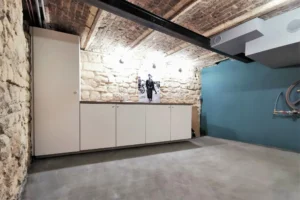 Bureau au sous-sol avec mur en pierre et rangements