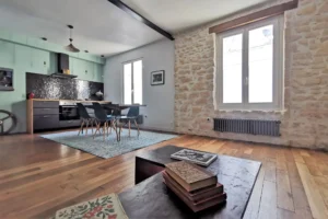 Séjour spacieux avec parquet bois et murs en pierre