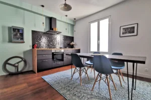 Coin repas lumineux avec tapis bleu et parquet bois clair