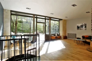 Local commercial lumineux à Paris 20ᵉ – escalier intérieur et lumière naturelle avec vue sur verdure