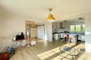 Séjour lumineux avec cuisine américaine ouverte dans maison à vendre à Pont-l’Évêque.