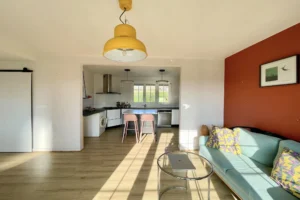 Pièce de vie traversante avec cuisine moderne et coin bureau, maison familiale à Pont-l’Évêque.