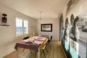 Salle à manger conviviale avec grande fenêtre dans maison à vendre à Pont-l’Évêque.