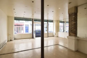 Intérieur d’un local commercial lumineux à vendre à Paris 19ᵉ, quartier Jaurès, avec grande vitrine sur rue passante.