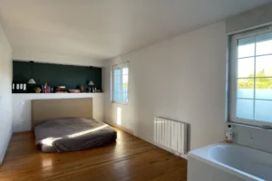 Chambre parentale spacieuse et lumineuse avec baignoire intégrée à Pont-l’Évêque.