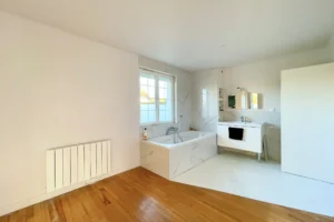 Salle de bains moderne avec baignoire et meuble vasque, espace parental à Pont-l’Évêque.