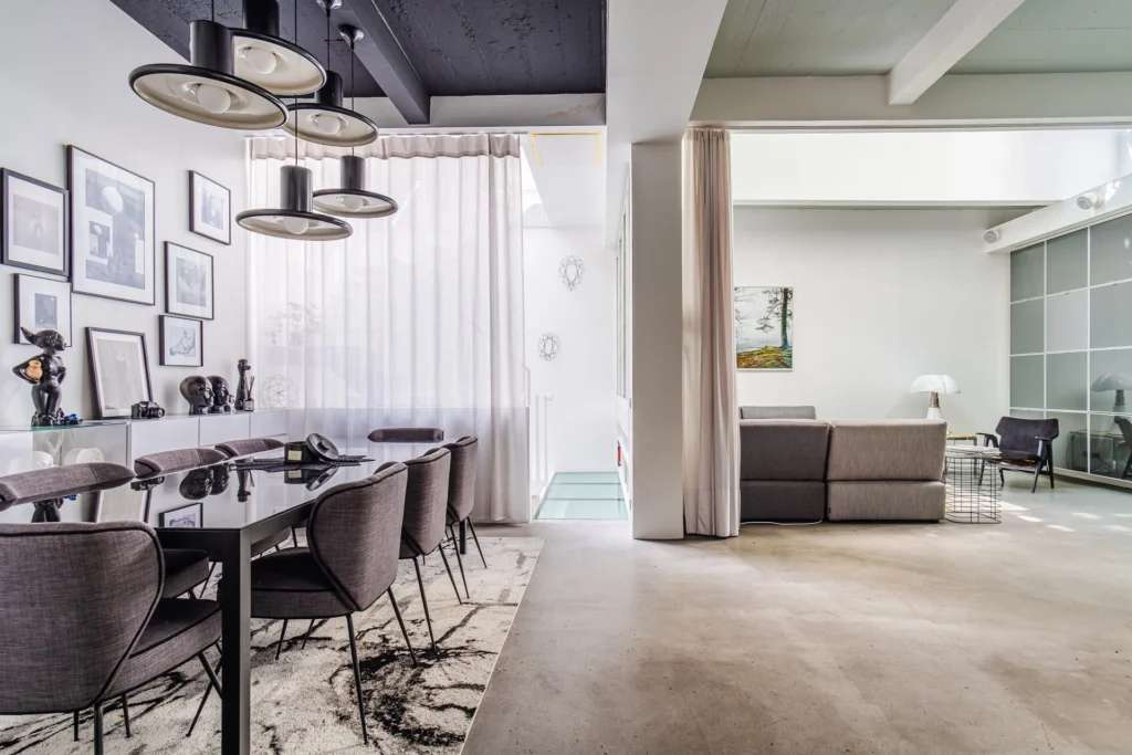 Vue élégante d’un loft à vendre à Paris 18, entre Barbès et Montmartre, avec salle à manger design, décoration contemporaine et double salon baigné de lumière naturelle.